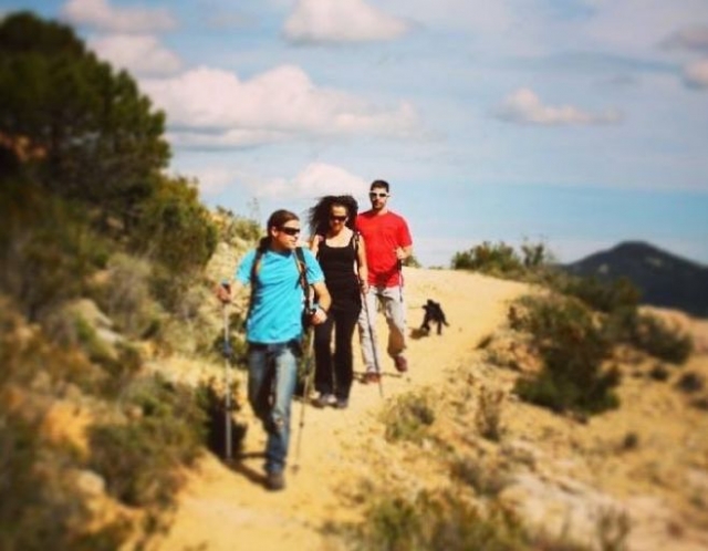 three friends walking a trail with their dog